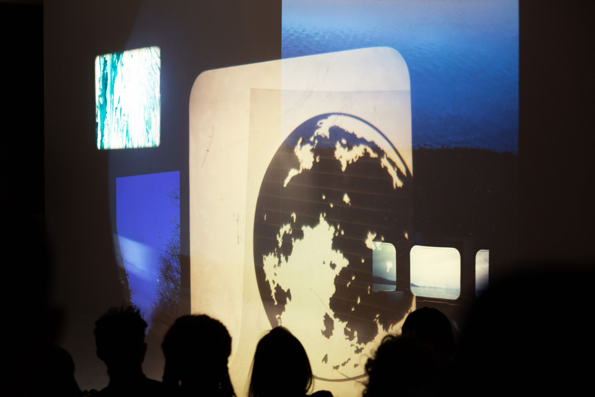 Abstract images including the moon projected in front of an audience.