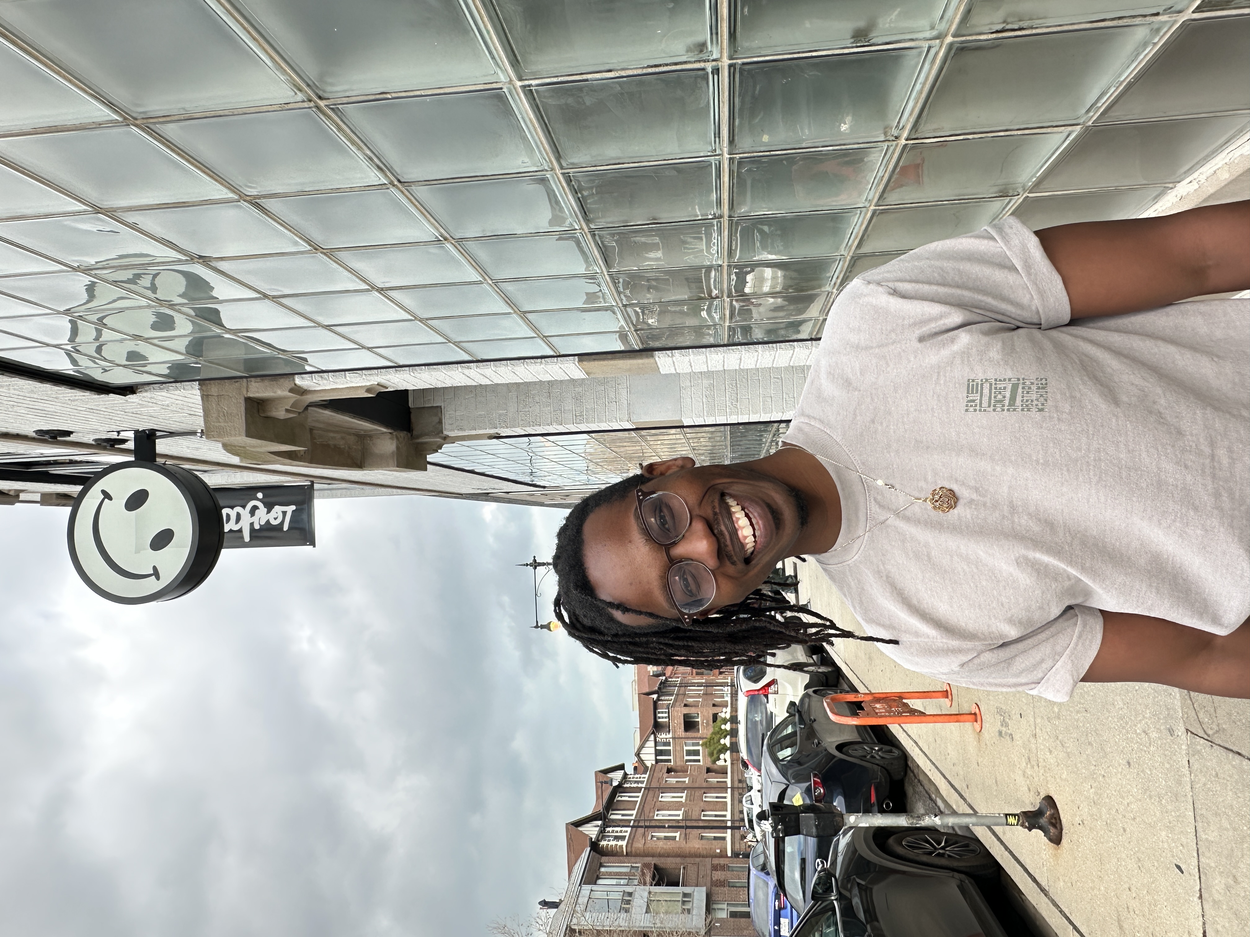 Model wearing CCAM x Public Works shirt in front of Public Works displaying shirt front